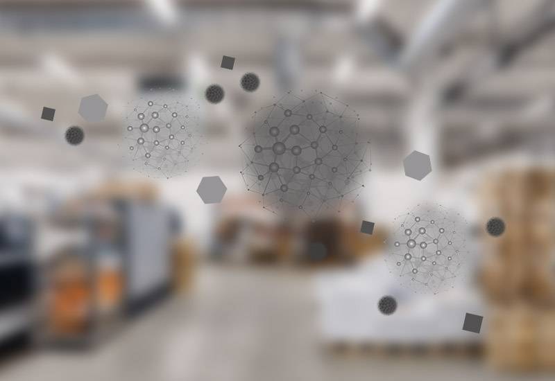 Blurred image of a warehouse in the background with an illustration of polluting particles in the foreground.