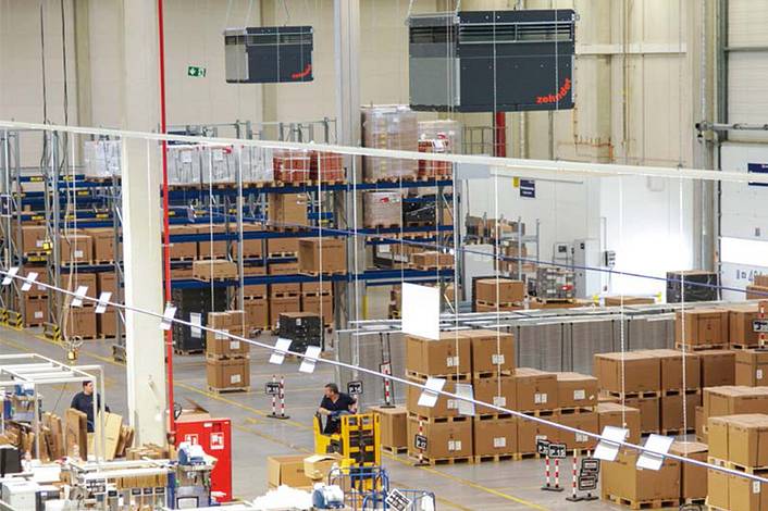 Industrial air purifier in a logistics hall with pallets full of boxes.