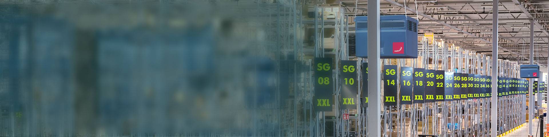 Industrial air purifiers hanging in a large logistics hall.