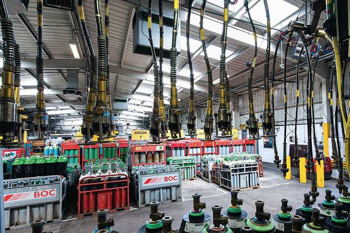 Industrial air purifier in an industrial hall with connected high-pressure pipes and gas cylinder storage.