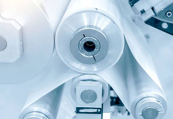 Plastic foil being transported over several rolls on a machine