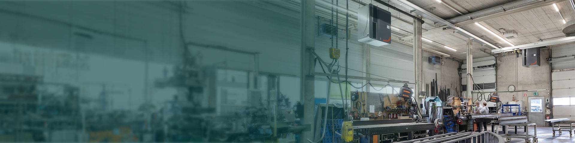 Industrial air purifiers hanging in a production hall.