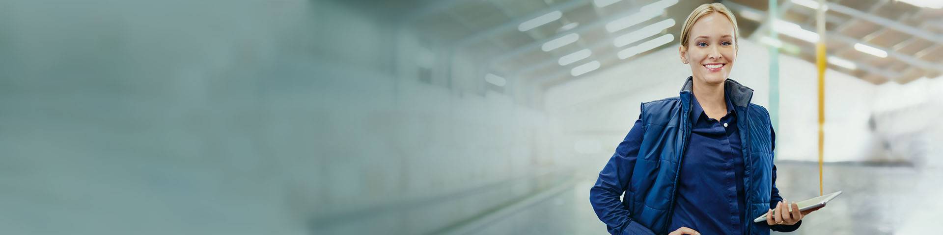 Service manager in a warehouse holding a clipboard