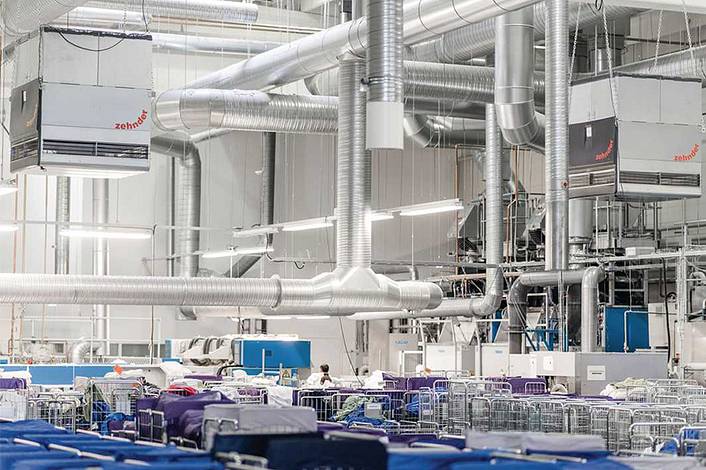 Industrial air purification systems hanging above production facilities in a textile factory.