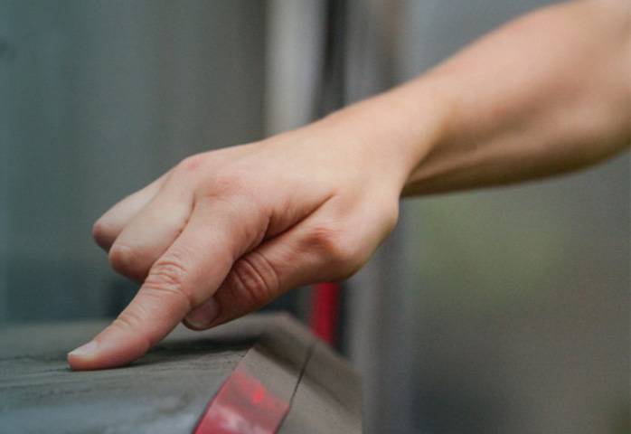 Finger draws a track in thick dust on a surface.