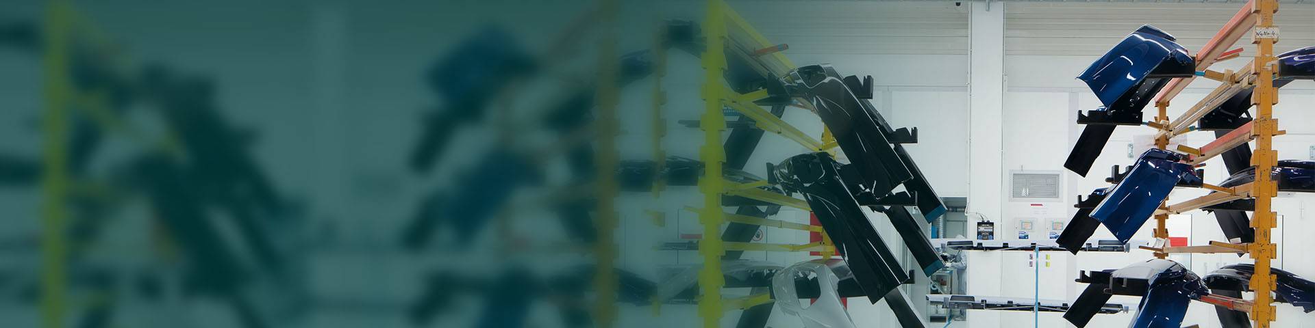 In a modern car factory, painted car parts are stored on a rack.