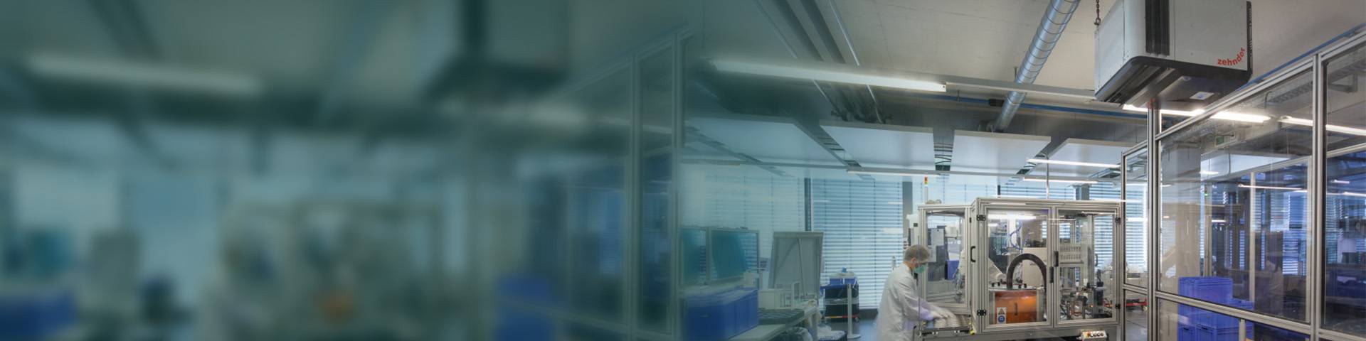 Indusitrial air cleaner in a medical technology production facility with automated machines and employees in protective clothing.