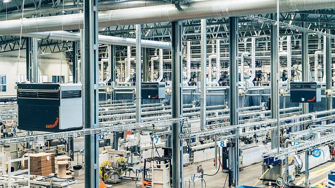 Modern industrial hall with automated production facilities and industrial air filtration systems.