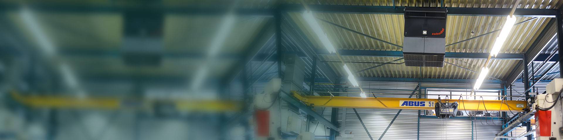 Industrial air purifier hanging from the ceiling of an industrial hall.