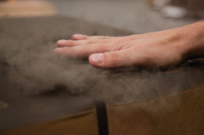 Hand touching a dirty parcel and whirling up dust