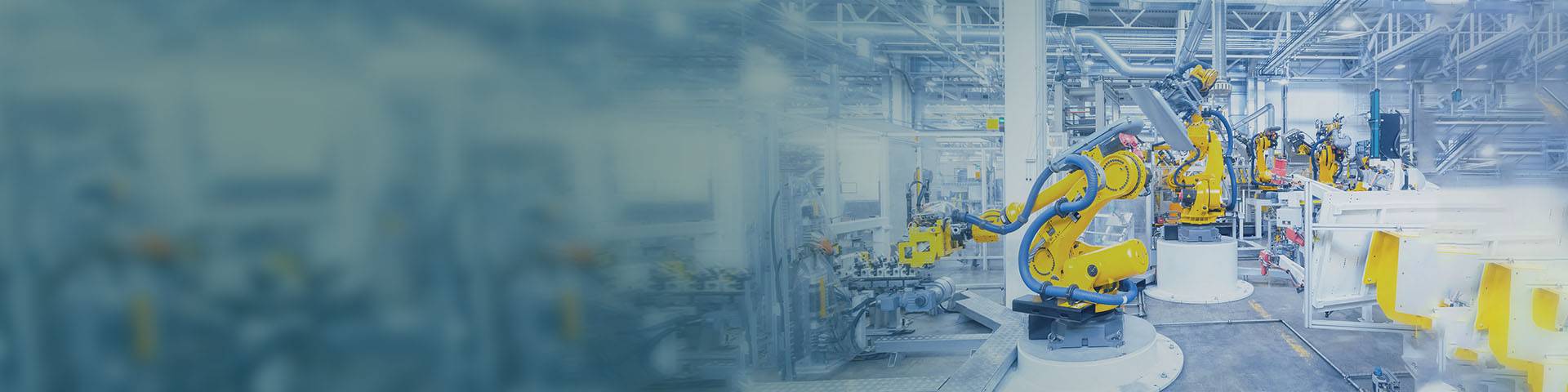 Robotic arms at work in an automotive production hall 