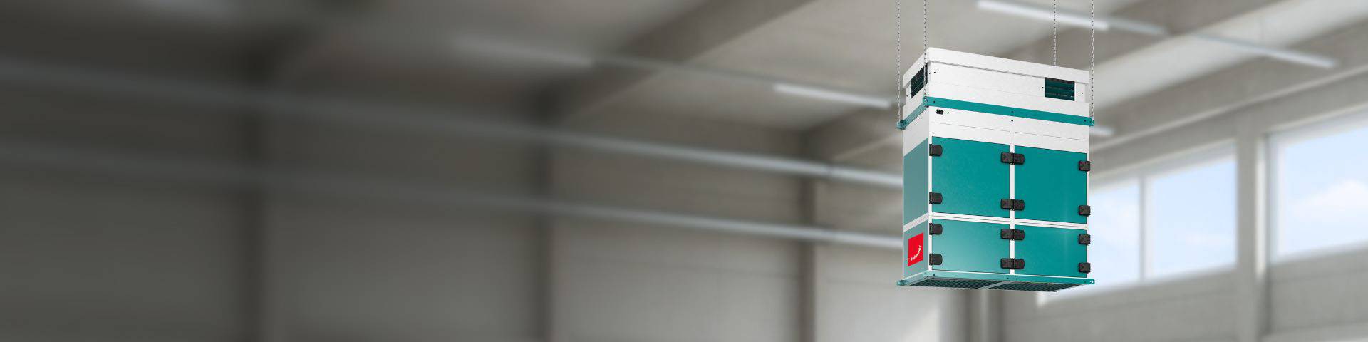 Industrial air purification system Zehnder CleanAir Max hanging from the ceiling in a clean and neutral industry hall