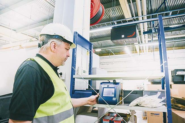 Zehnder employee making a dust measurement in a hall