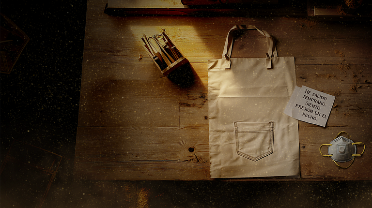 An apron in a wood workshop laying on the floor with some tools and a post.it saying that the person went home because they felt sick