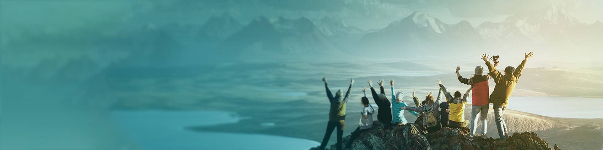 A group of people on top of a mountain celebrating their success as a team