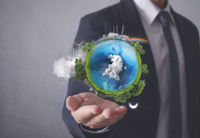 Manager in business outfit holding a green earth ball above his hand