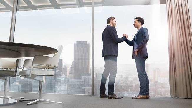 Two managers shaking hands in a modern office