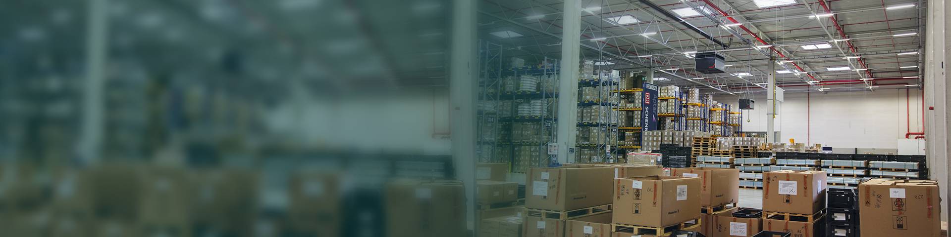 Industrial air purifier in a logistics hall with high shelves.