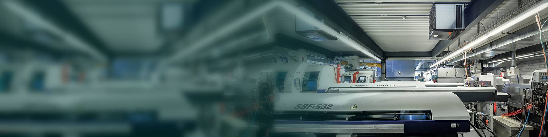 Industrial air purifier above production equipment in an industrial hall.