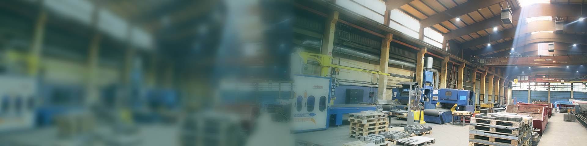 Large industrial hall with machines, pallets and modern air filtration systems.