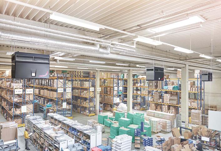 Industrial air purification systems are installed in a logistics hall with many high-bay warehouses.