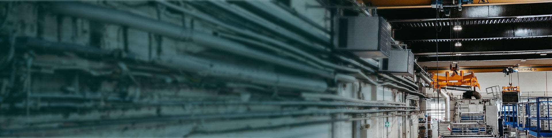Industrial air purifiers hanging in an industrial hall.